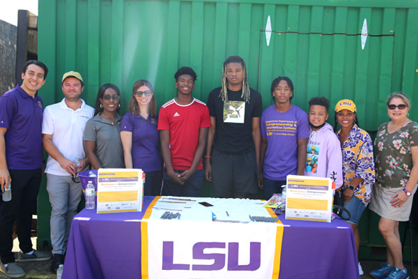 Group of people behind a table with LSU table cloth