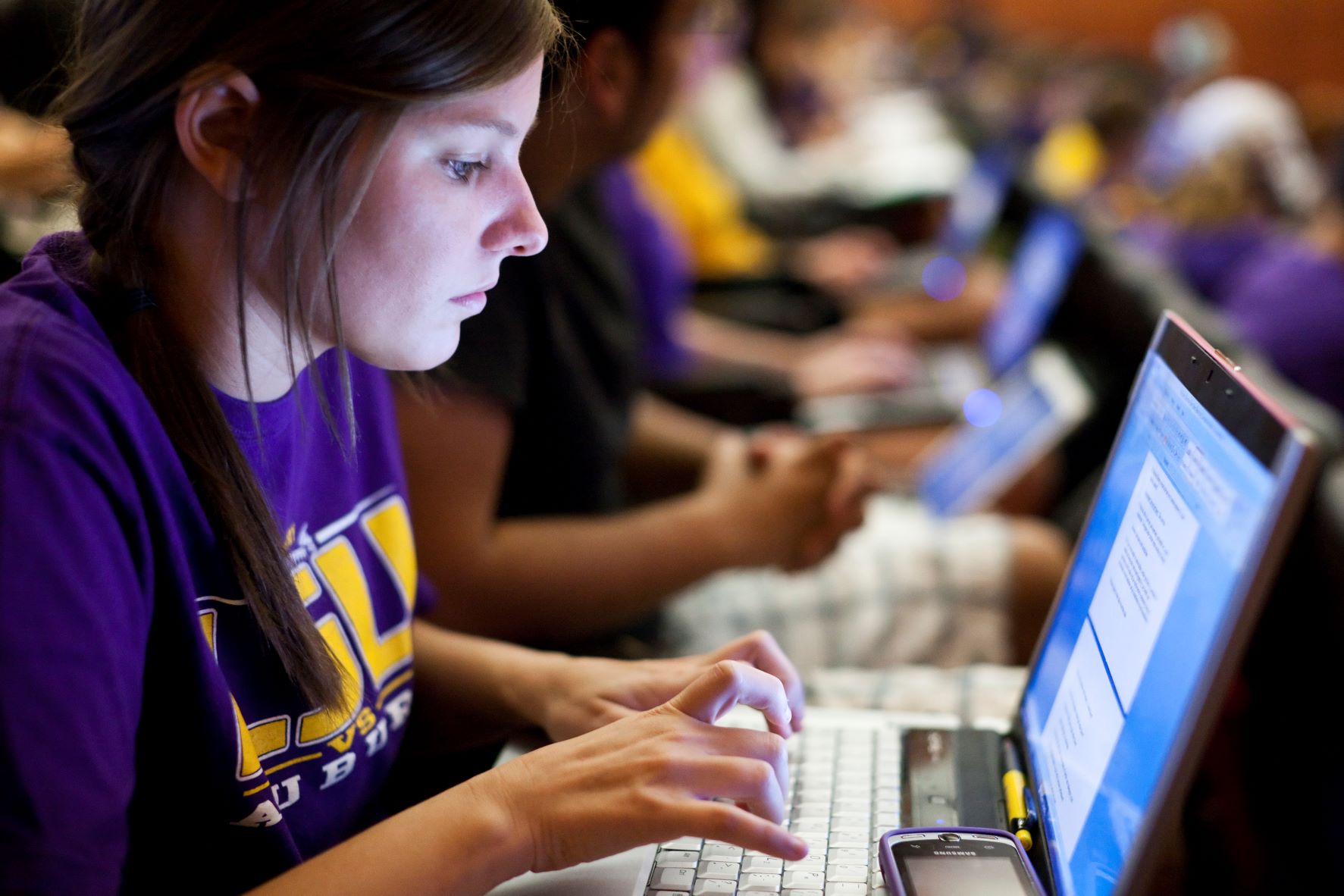 Female student types on laptop.
