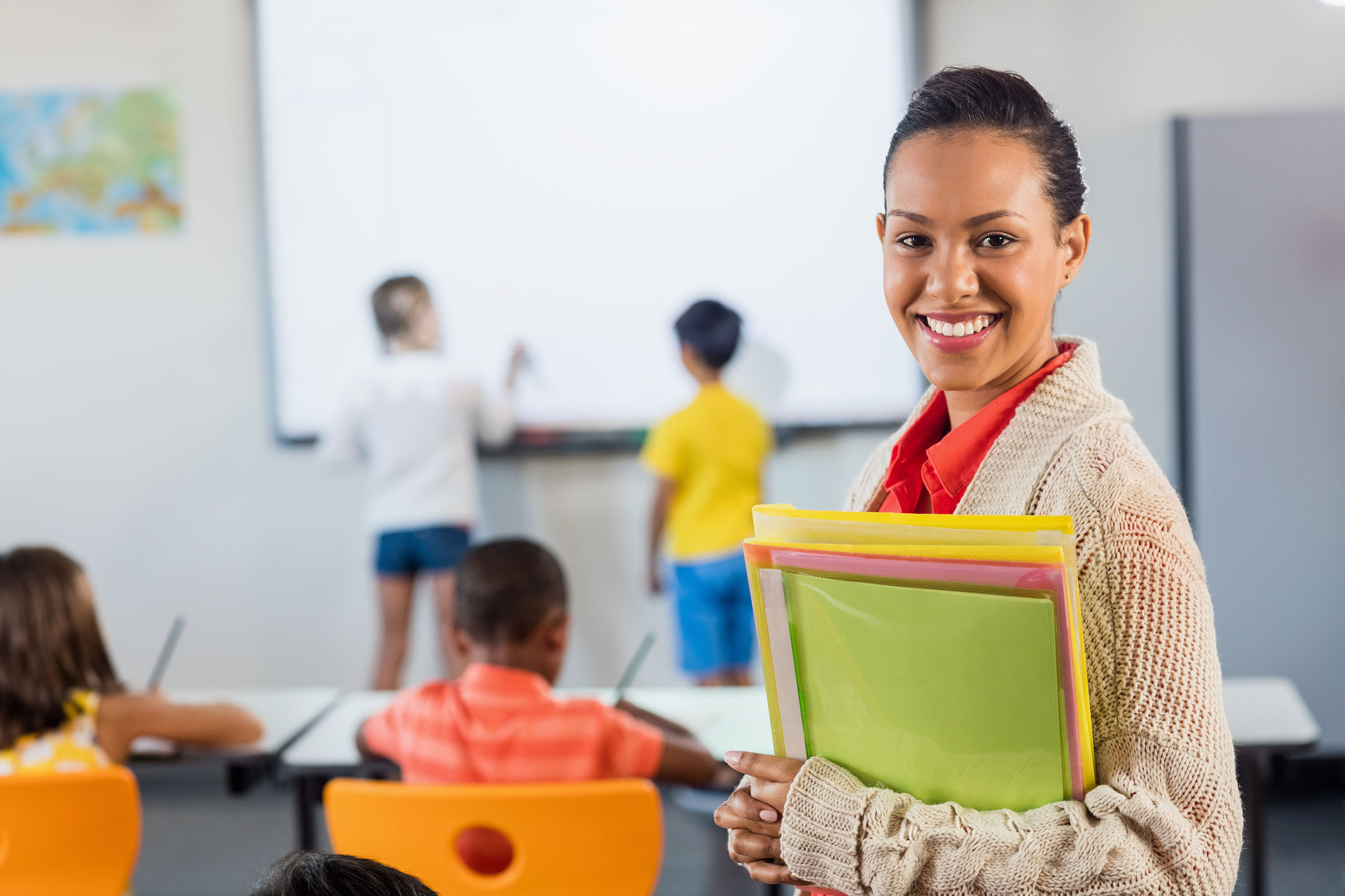 teacher smiling at back of classroom
