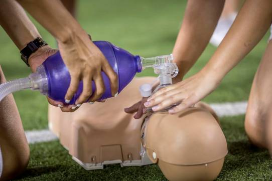 photo hands using cpr tool on medical dummy