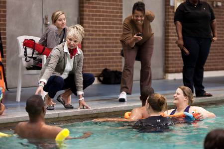 professor instructing swimming students at pool