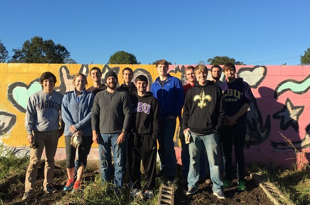 Group photo of students in front of a painted mural wall