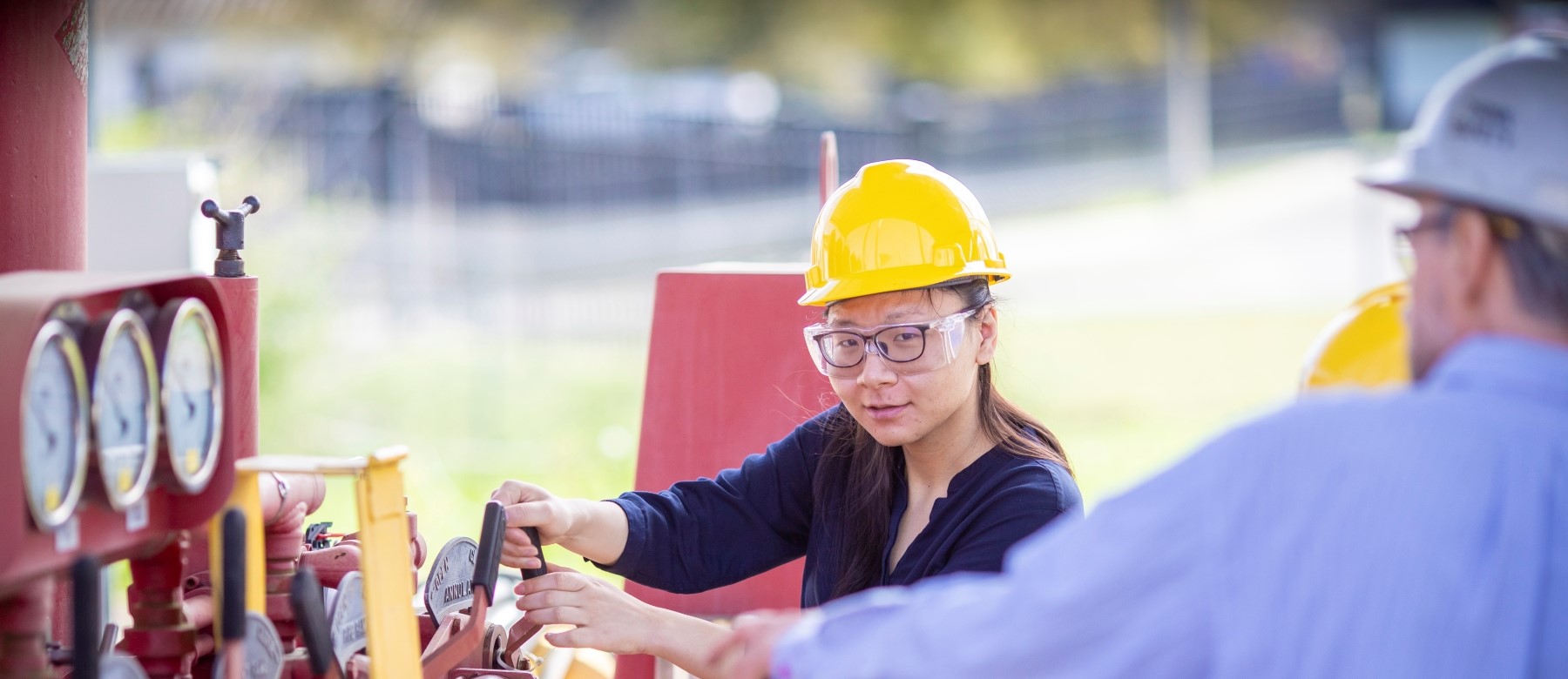 student with hard hat works on an engineering project