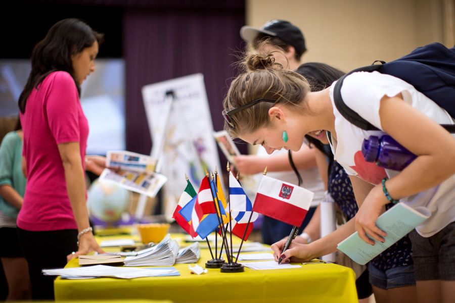 student signs up for an activity at an event table