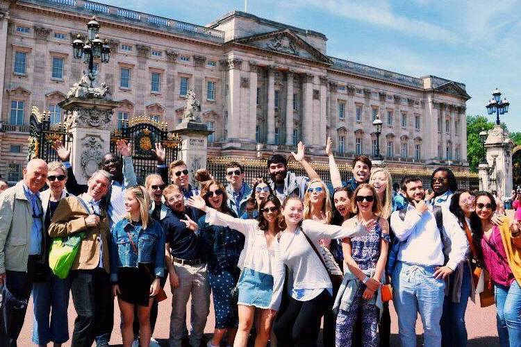 Smiling students in front of Buckingham Palace in London, England